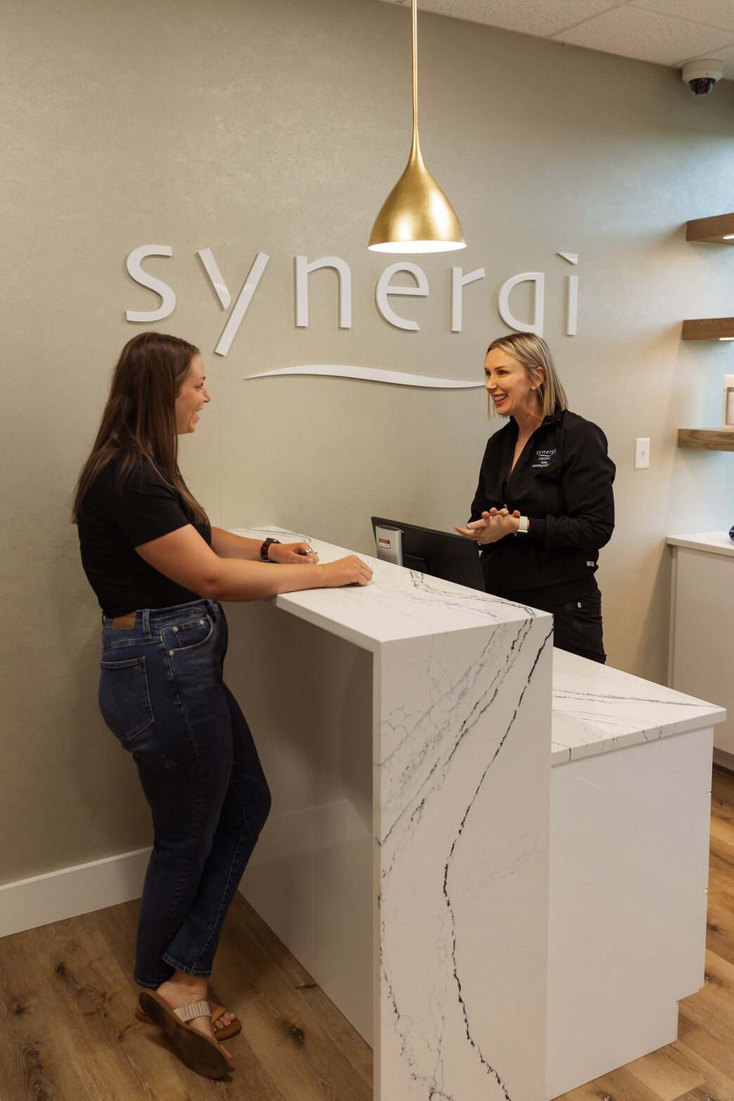 Photo of Kelley with a patient at the front desk